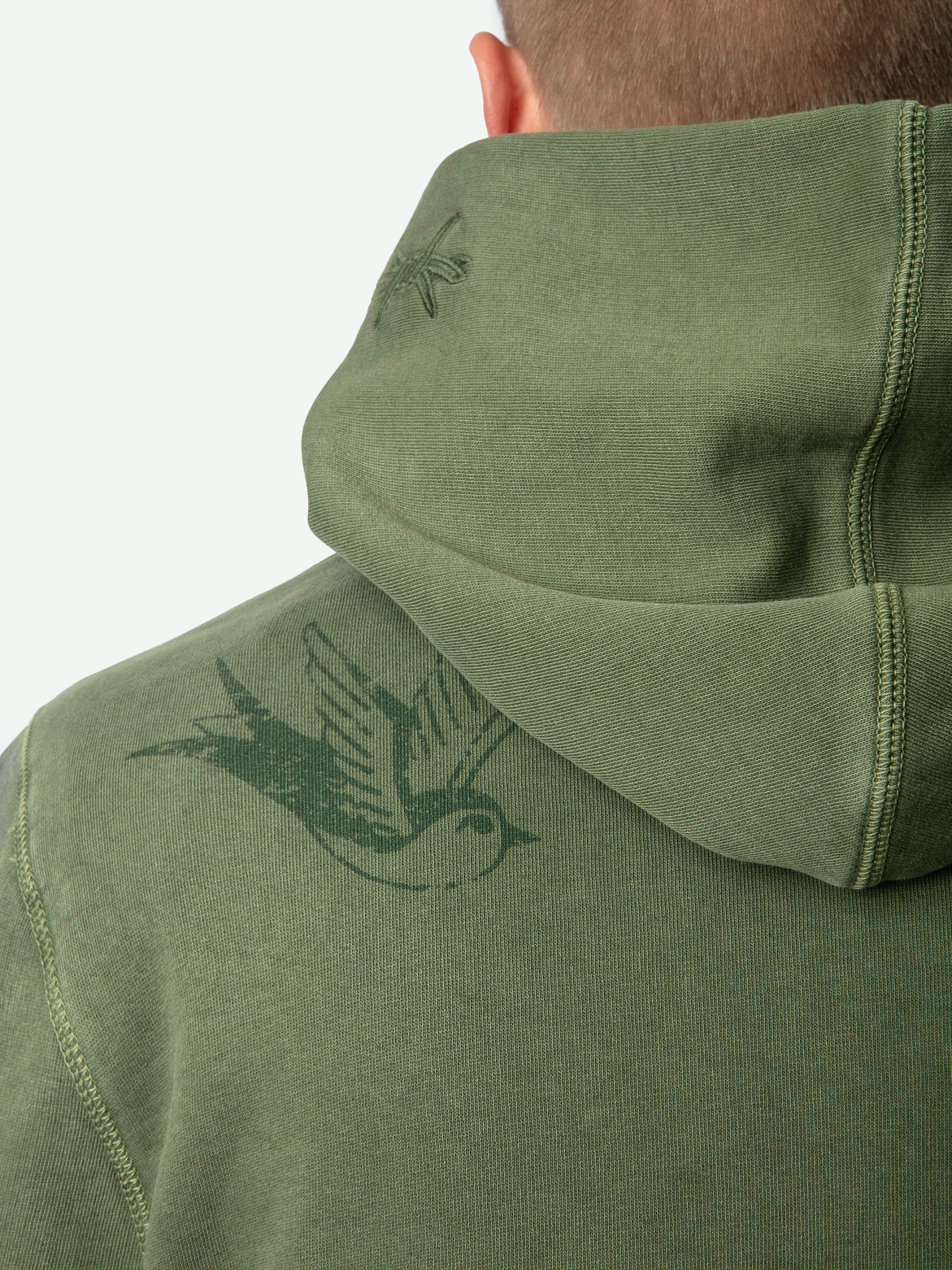 Sudadera Sanchi - Sudadera de algodón orgánico con efecto desgastado en color caqui, con capucha, mangas largas con estampados y bordados de tatuajes.
